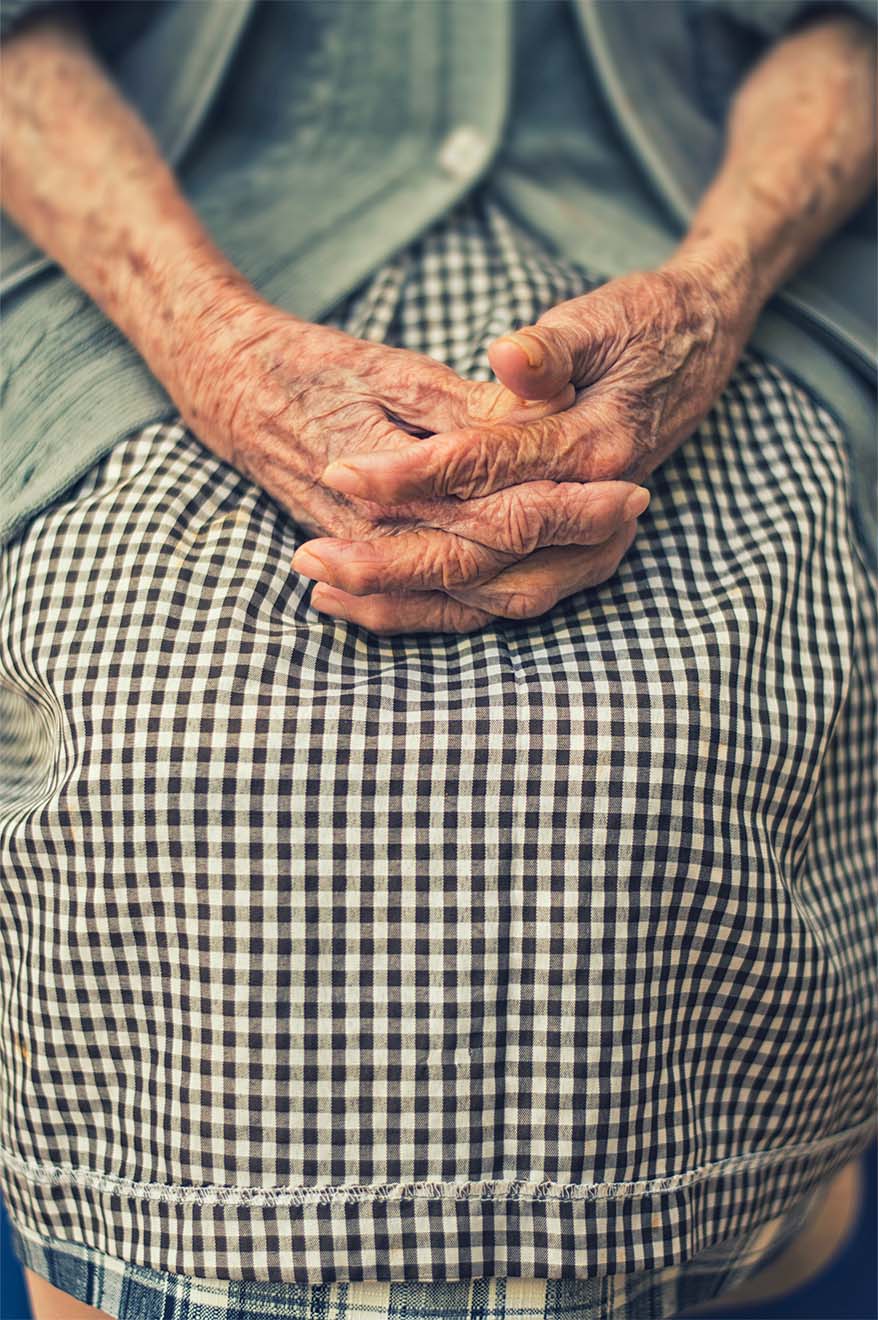 Hands clasped in lap