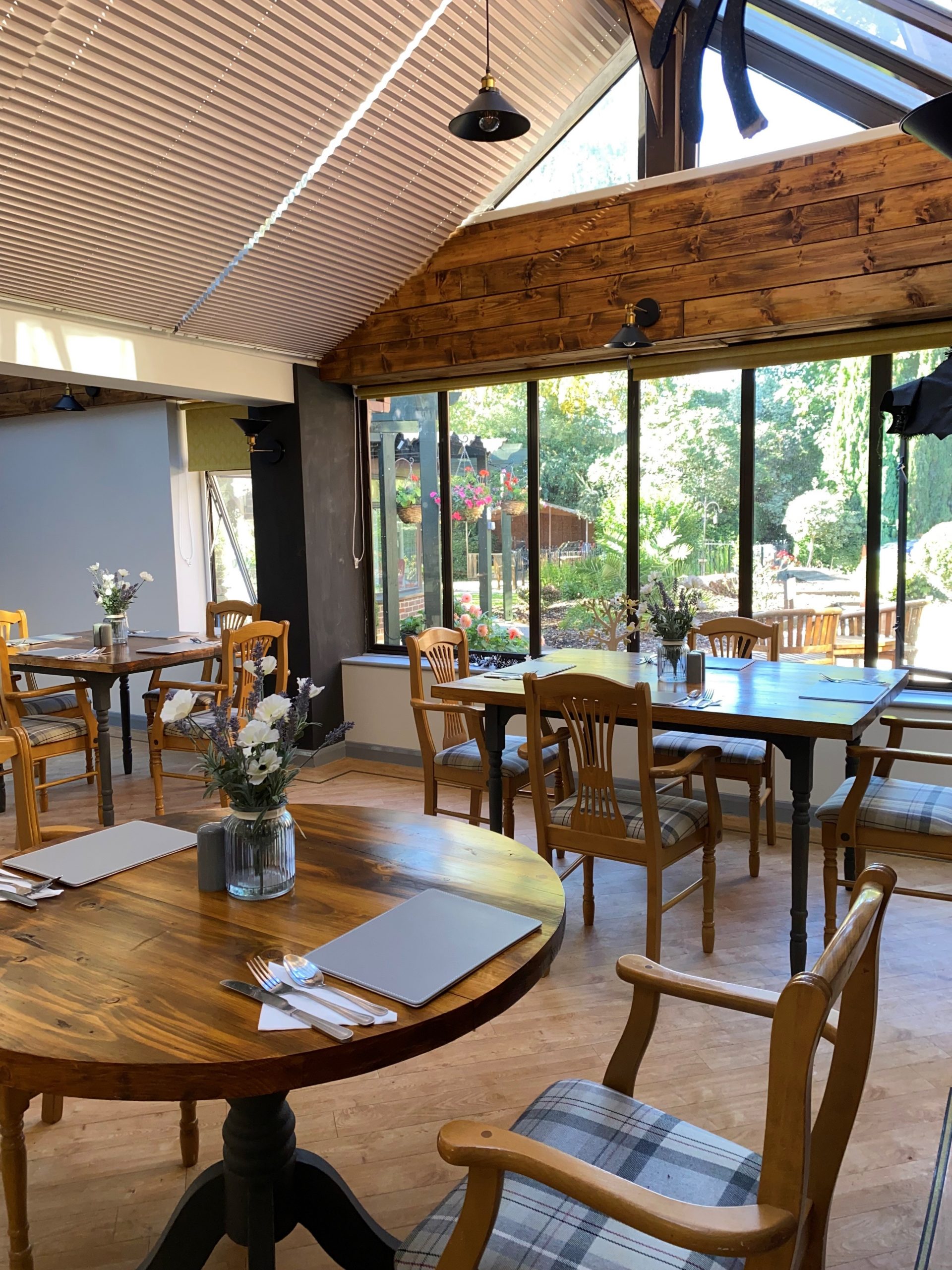 Dining room in care home with wooden tables and views to the garden