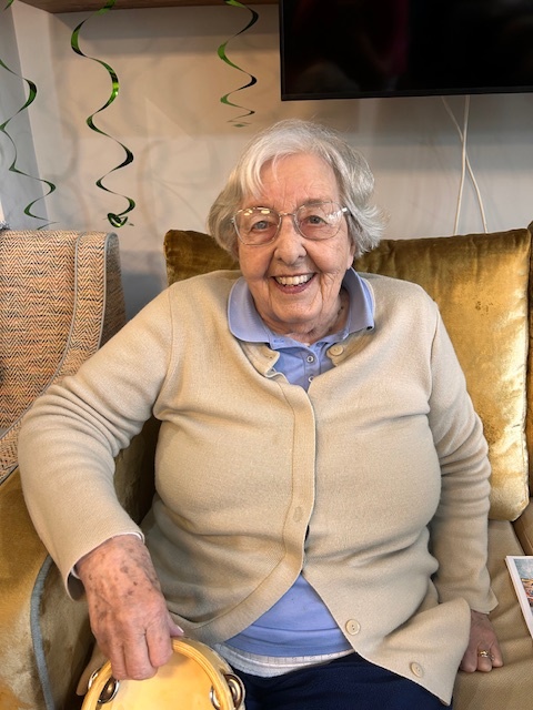 resident sat smiling in armchair