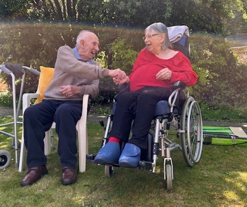 residents sat outside smiling together and chatting