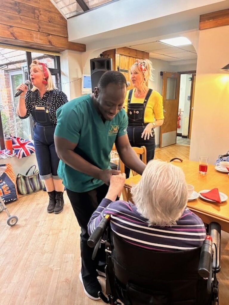 resident sat with team member enjoying a day performance