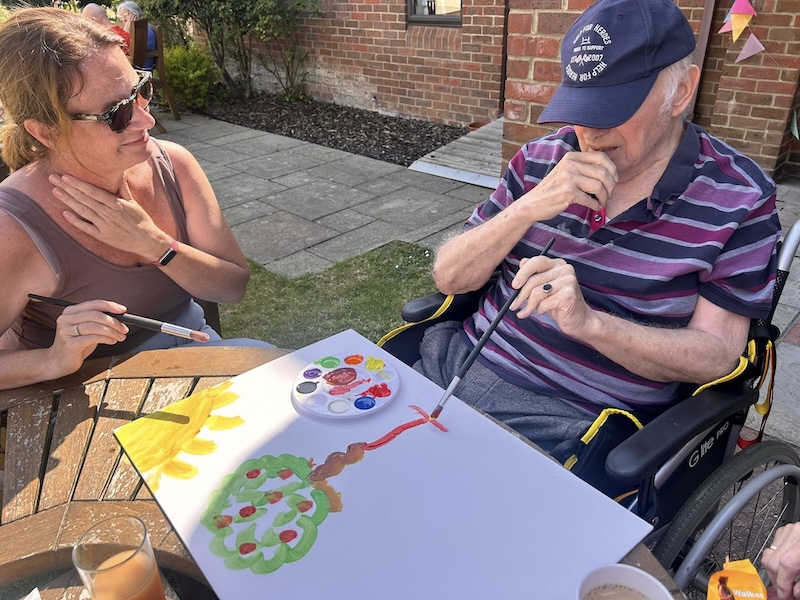 one of our residents sat painting a tree on a canvas