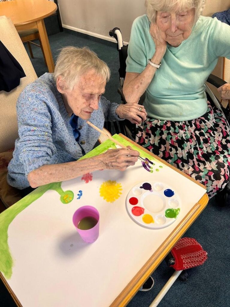 one of our residents sat painting a canvas