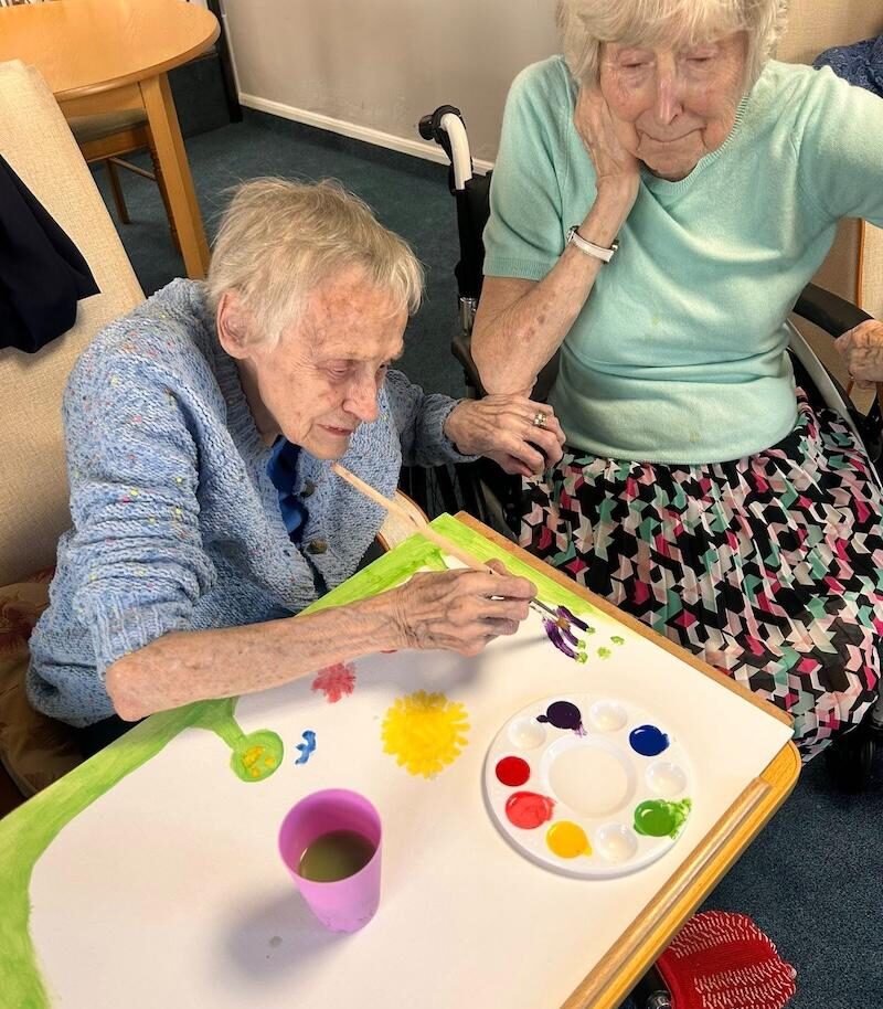 one of our residents sat painting a canvas
