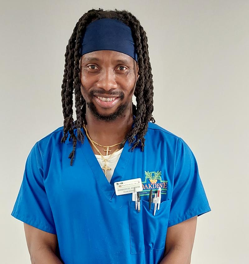 male team leader with brown hair in a blue uniform smiling for his team photo