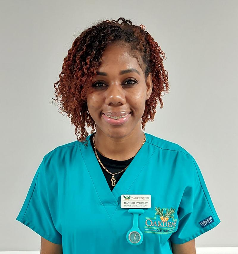 female senior carer with brown hair smiling for her team photo