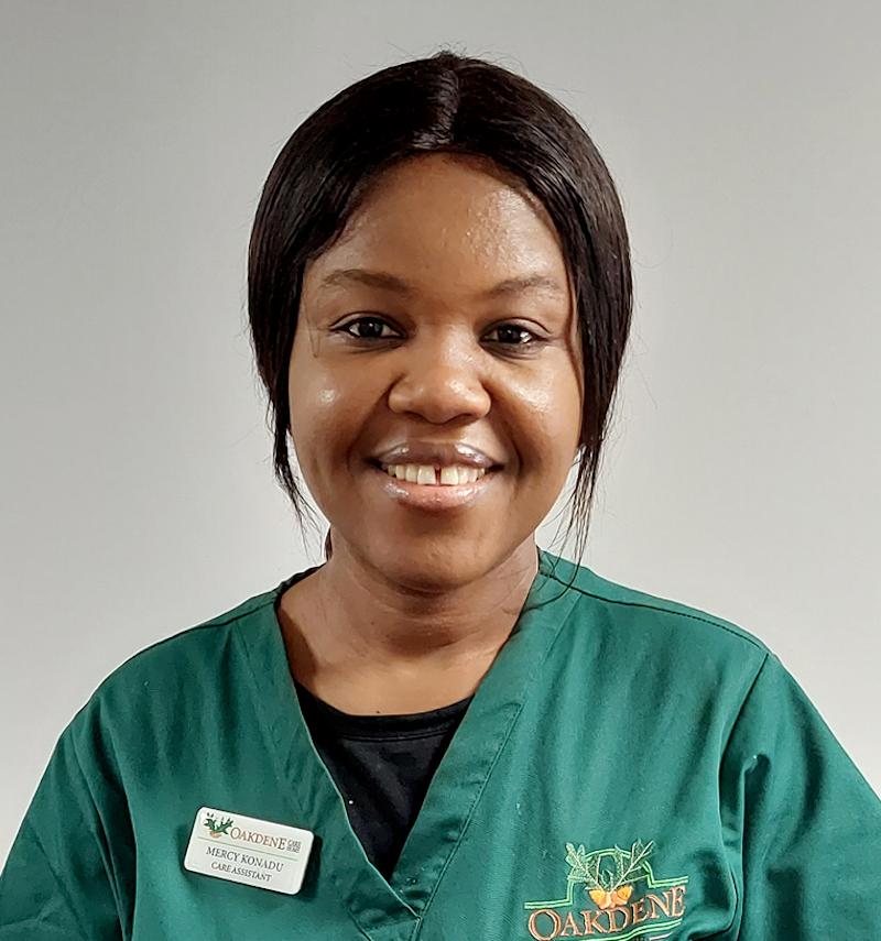 female senior carer with brown hair smiling for her team photo