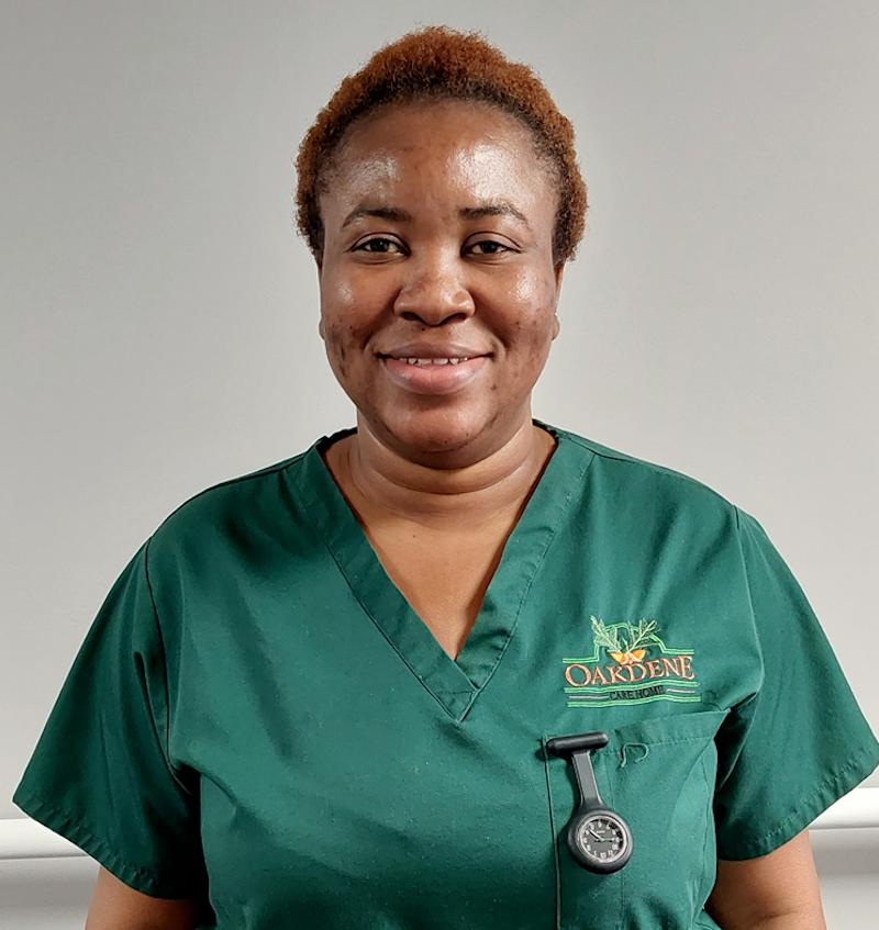 domestic supervisor in a green uniform smiling for a team photo